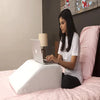 Memory foam wedge pillow used as back support while sitting up in bed